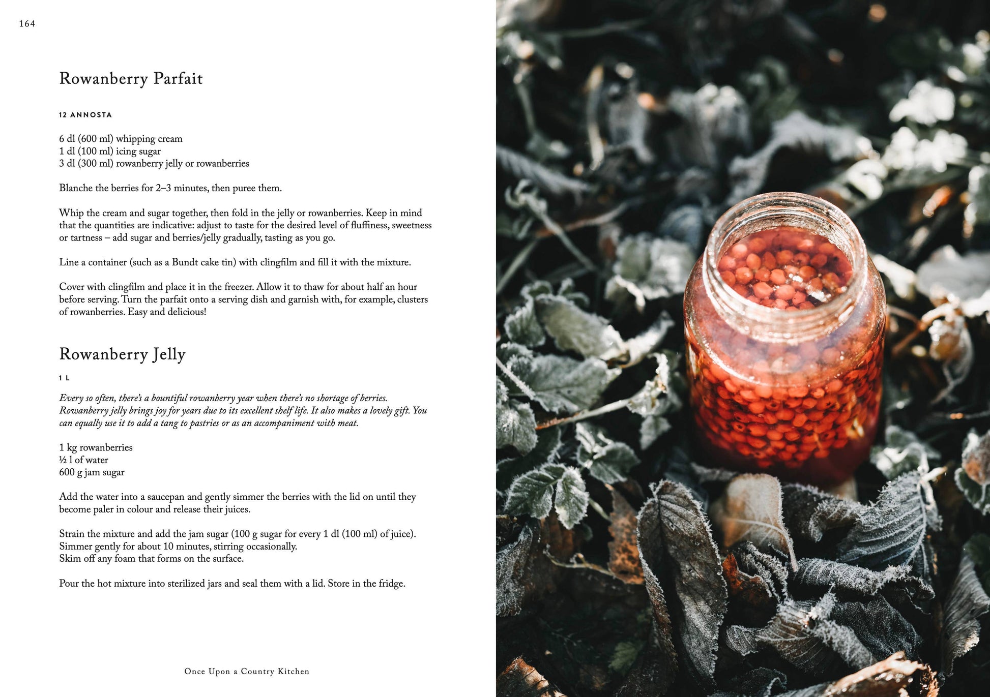 Ein Glas mit roten Vogelbeeren steht zwischen frostigen Blättern und vermittelt rustikale Reinheit. Das Bild zeigt Rezepte für Vogelbeerparfait und -gelee aus dem Kochbuch „Once upon a country kitchen“ von Cozy Publishing.