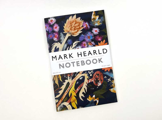 Das Art Angels - Notizbuch Sonnenblumen und Michaelmas von Mark Hearld zeichnet sich durch ein lebhaftes Blumen- und Blattmotiv auf einem dunklen Einband aus, der auf einer weißen Fläche platziert ist.