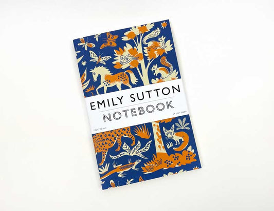 The Art Angels - Notizbuch Nacht und Tag von Emily Sutton hat einen blau-orangefarbenen Einband mit illustrierten Tieren und Pflanzen sowie einen weißen Streifen in der Mitte, der den Titel und den Namen der Autorin zeigt.