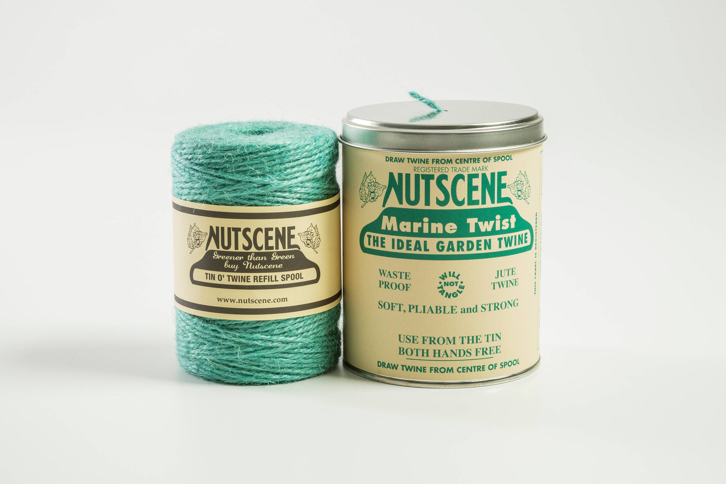 Eine Spule Nutscene-Gartenschnur steht neben der legendären Schnur in einer Dose (490 Fuß) von Nutscene Twines Ltd., beide mit der Aufschrift „Marine Twist – Die ideale Gartenschnur“. Aus dem Deckel der Dose kommt die dreilagige Juteschnur.