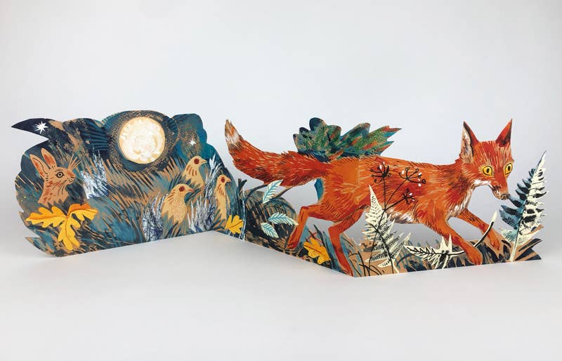 Die Fuchs Collage Karte von Mark Hearld by Art Angels zeigt einen leuchtend roten Fuchs mit gelben Augen in einem Wald unter einem sternenklaren Nachthimmel, umgeben von Pflanzen, Kaninchen und einem Vollmond im unverkennbaren Stil von Mark Hearld.