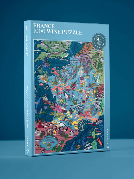 Die farbenfrohe Schachtel des Water & Wines - Wein Puzzle - Frankreich (1000 Teile) steht aufrecht vor einem blauen Hintergrund und zeigt eine lebendig illustrierte Karte der französischen Weinregionen sowie den Markennamen Water & Wines auf dem Deckel.