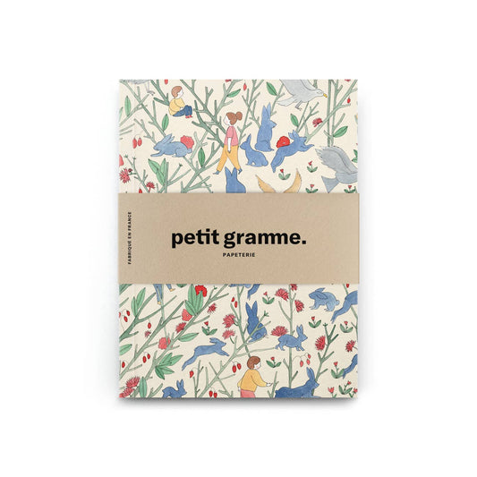 Das Petit Gramme - Alice Pocket-Notizbuch von Petit Gramme ist nachhaltig gestaltet, zeigt bunte Illustrationen von Tieren und Pflanzen auf dem Cover und wird von einer beige Papierbanderole mit "petit gramme. papeterie." umhüllt.