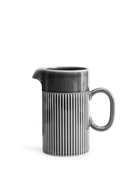 Die Sagaform Coffee & More Kanne der Sagaform GmbH ist eine graue Keramikkanne mit gebogenem Henkel und Ausguss. Sie zeichnet sich durch vertikale Rillen in der unteren Hälfte und einen glatten oberen Teil aus, alles vor einem schlichten weißen Hintergrund.