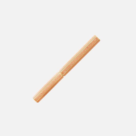 Der ENTREPÔT YSTUDIO Klassische Renaissance KAZARI KANAGU ORCHID Tintenroller, ein pfirsichfarbener Tintenroller mit goldenen Blumenmustern, die von Kazari Kanagu inspiriert sind, steht diagonal auf weißem Grund.