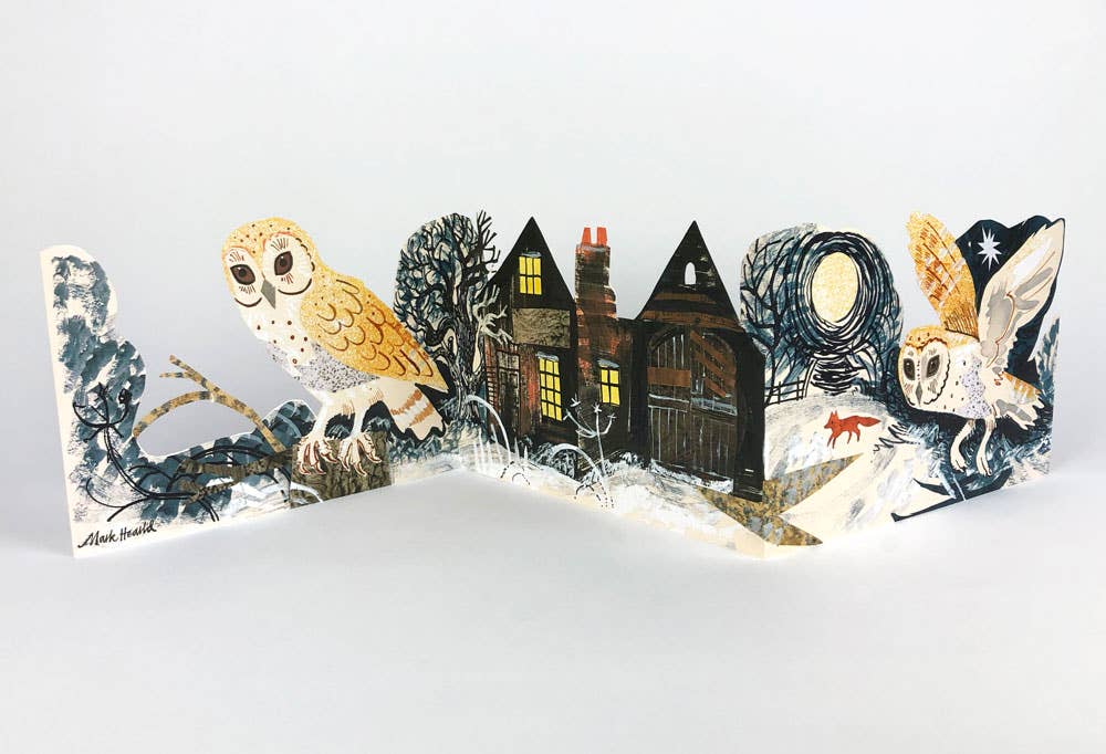 Die Art Angels - Silent Flight Collagekarte von Mark Hearld zeigt zwei Eulen und ein Haus mit leuchtenden Fenstern in einer verschneiten Nacht, während ein roter Fuchs zwischen Bäumen und Sternen spazieren geht - und fängt damit den Zauber von Silent Flight ein.