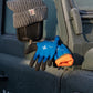 Eine graue Strickmütze und ein Paar Niwaki Winterhandschuhe von Niwaki, warm, wasserabweisend und bequem in Blau und Orange, liegen auf dem Seitenspiegel und der Tür eines frostbedeckten dunkelgrünen Fahrzeugs.