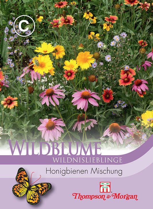 Eine lebendige Wiesenmischung aus Wildblume Honigbienen Mischung von Thompson und Morgan, mit rosafarbenen Kegelblumen, gelben und orangen Blüten. Die Verpackung zeigt eine Schmetterlingsillustration, deutschen Text und das Thompson und Morgan-Logo.