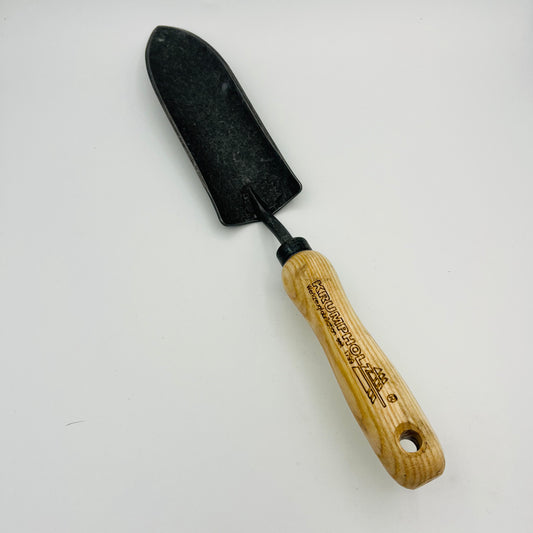 Die Krumpholz Pflanzkelle schmal von Krumpholz verfügt über eine schwarze Metallschaufel und einen hellen Holzgriff mit eingraviertem Text, fotografiert auf Weiß – perfekt für präzise Pflanzlöcher und ein unverzichtbares Gartenwerkzeug.